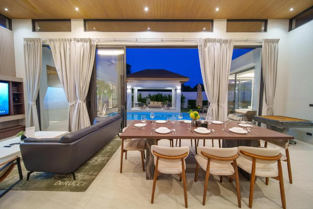 Open-plan dining room with pool view at night
