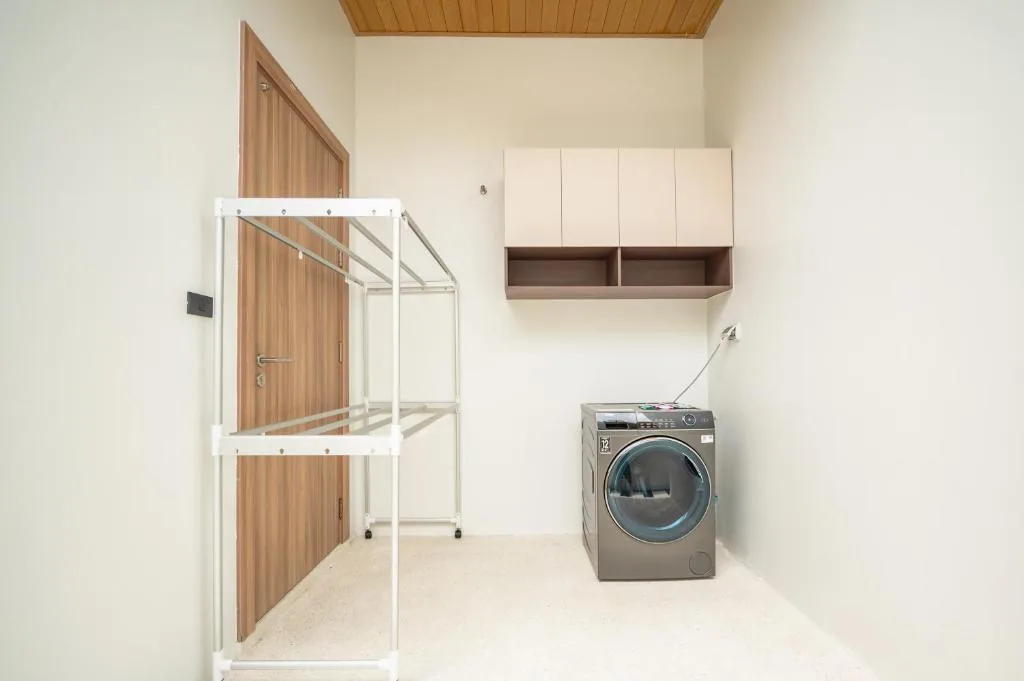 Villa laundry room with washer and storage